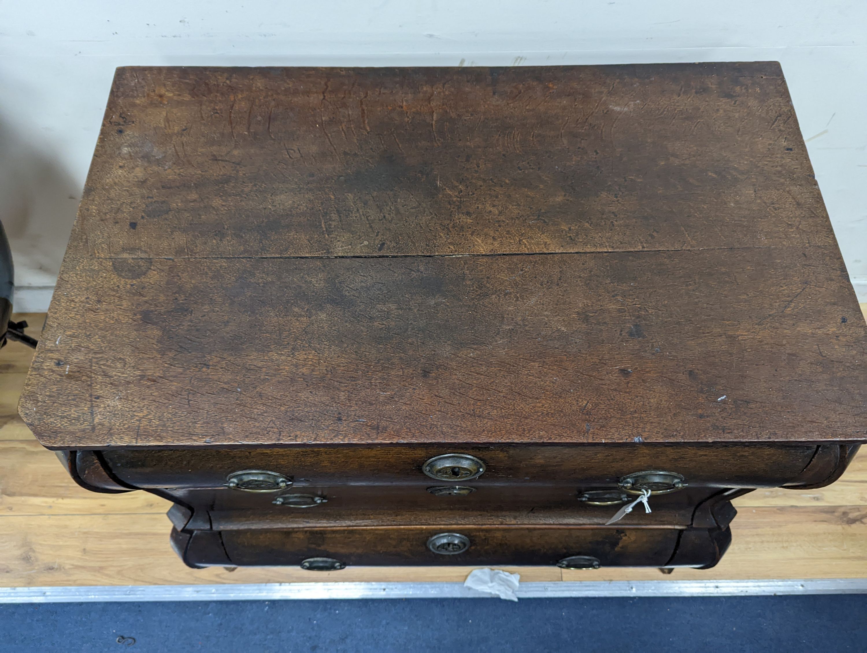 An 18th century Dutch oak three drawer bombe chest, width 94cm, depth 50cm, height 76cm